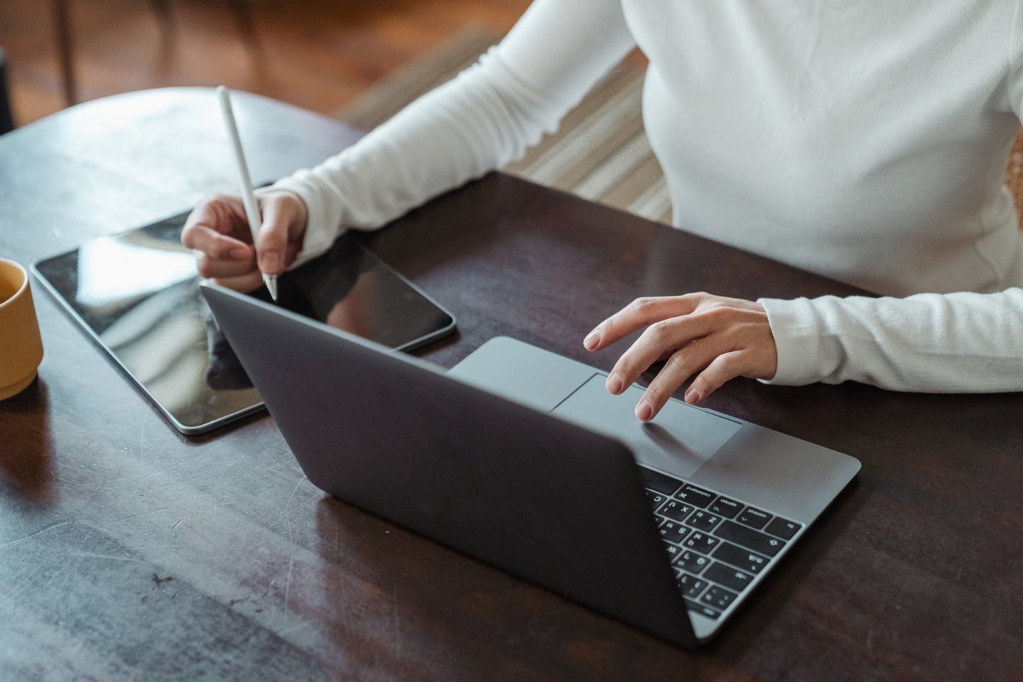 crop faceless female entrepreneur doing multitasking work on different devices